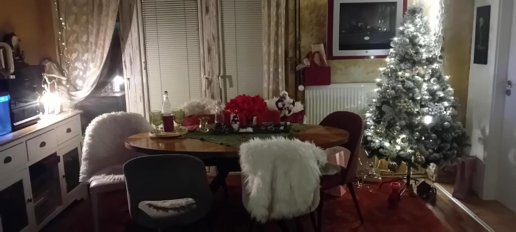 een woonkamer met een kerstboom en een tafel en stoelen bij ART ROOM in Rose resort in Ljubljana