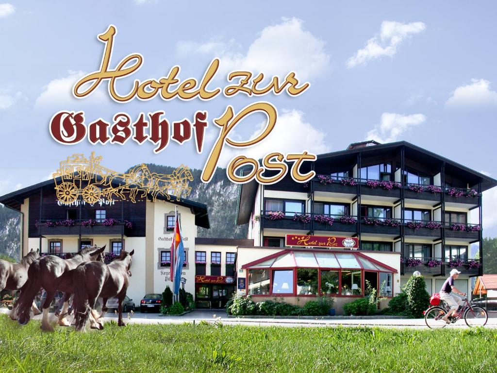 ein Hotel mit Pferden vor einem Gebäude in der Unterkunft Gasthof Hotel zur Post in Kiefersfelden