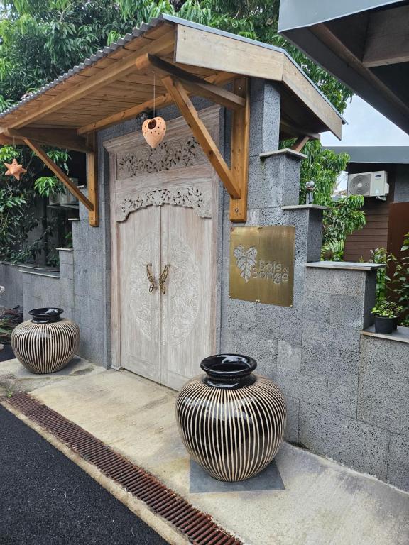 twee grote vazen voor een deur bij Bois de Songe in Sainte-Rose