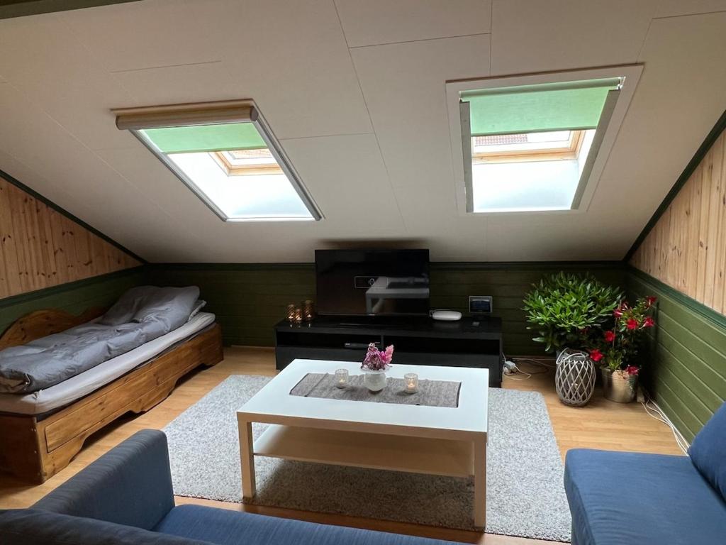 een zolderwoonkamer met een bed en een tafel bij Apartment in barn in Gran