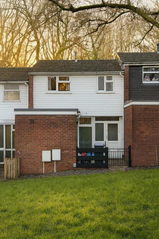 a white house with a red brick at Comfortable Two Bedroom Home in Cwm-brân