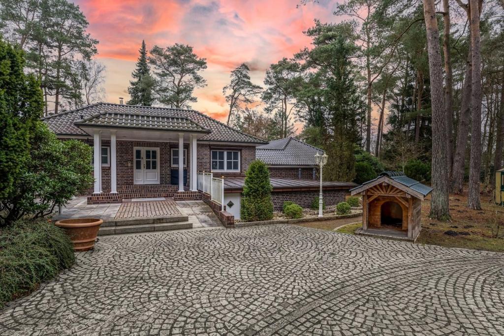 a house with a brick driveway in front of a house at NEU! HeideVilla - Private Pool, Sauna & Mini Golf in Asendorf