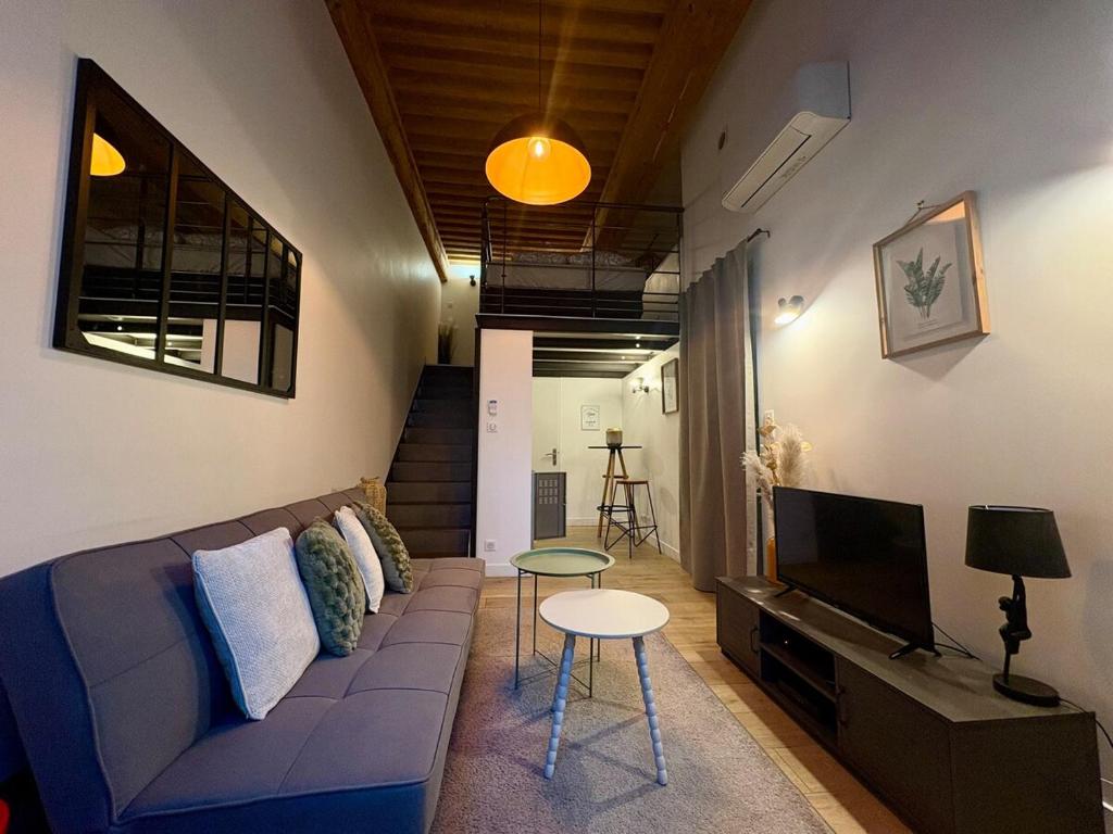 een woonkamer met een bank en een flatscreen-tv bij NEW - Croix Roussienne at night in Lyon