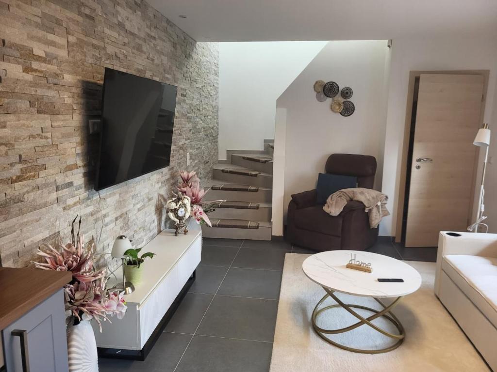 een woonkamer met een tv aan een bakstenen muur bij Ferienhaus Neunkirchen-Daun in Daun