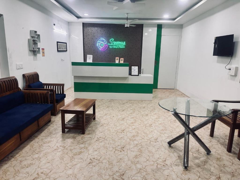 een wachtkamer met een bank en een glazen tafel bij Starfalls Eco Beach Resort 