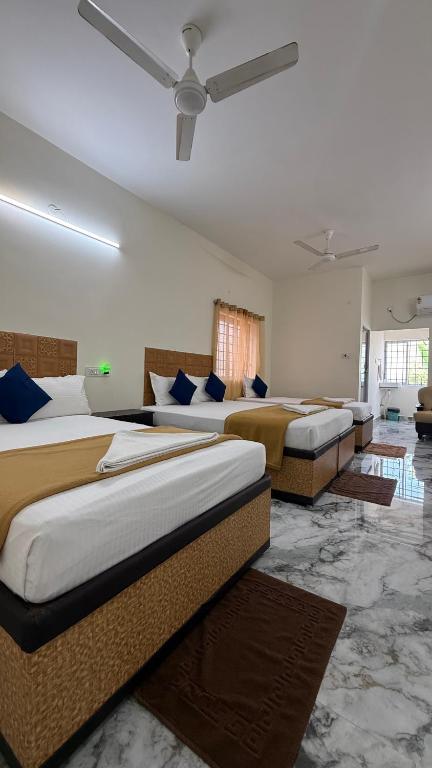 a room with three beds and a ceiling at DSS HOME STAY Just 500 Meter Girivalam Road in Tiruvannāmalai