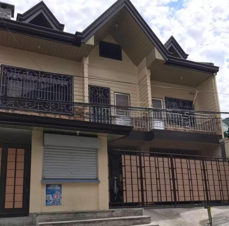 a house with a balcony and a gate at CJ&K Baguio Lodge in Baguio