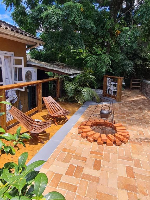 a patio with two chairs and a fire pit at Casa da Rosa caminho das praias Florianópolis in Florianópolis