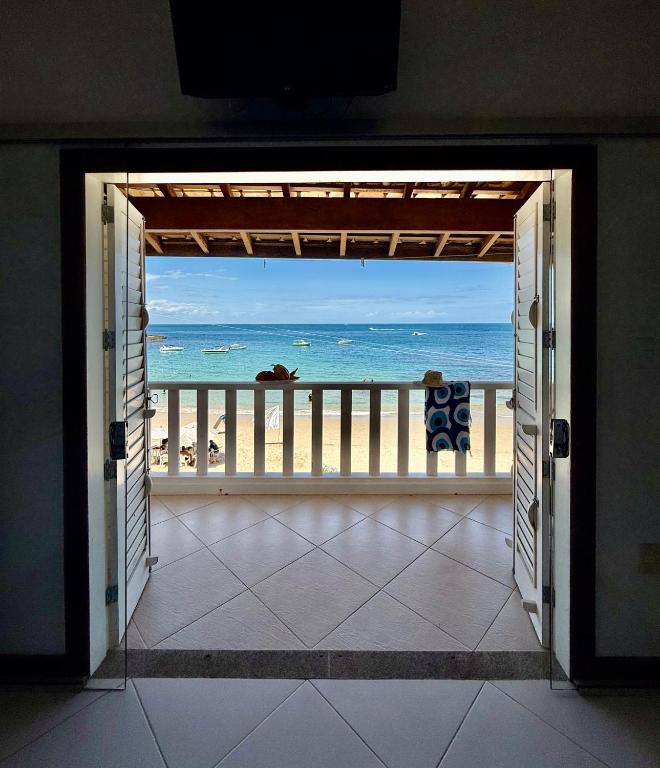 an open door to a balcony with a view of the beach at Casa Varandão, 1ª praia, Morro de São Paulo in Cairu