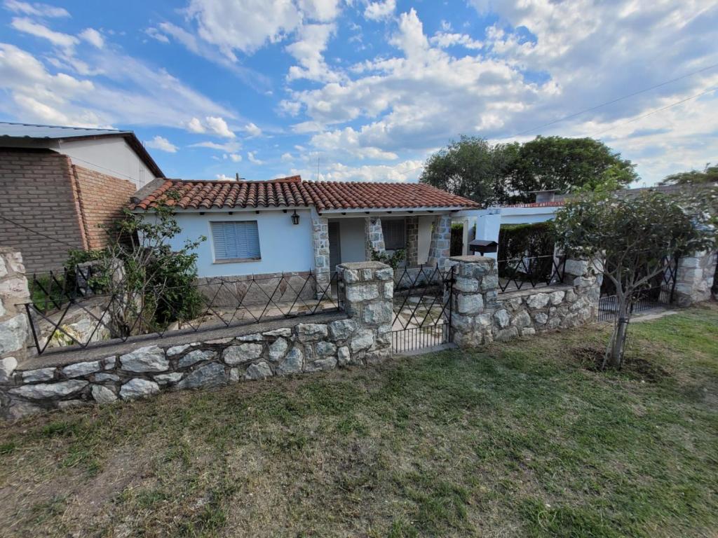 a house with a stone fence in the yard at Casa Paraiso Serrano in Valle Hermoso