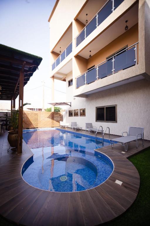 a swimming pool in front of a building at Cherry Signature Condos in Adentan