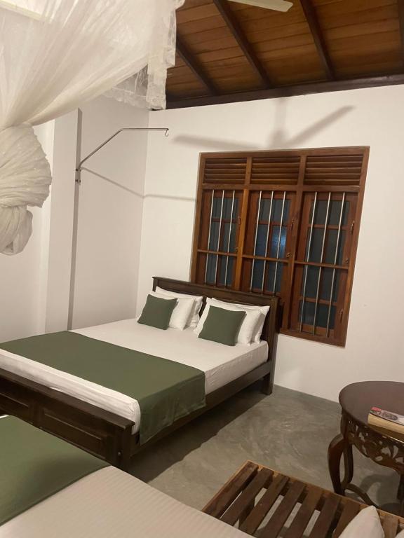 - une chambre avec un lit doté d'oreillers verts et blancs dans l'établissement Royal Resort, à Weligama