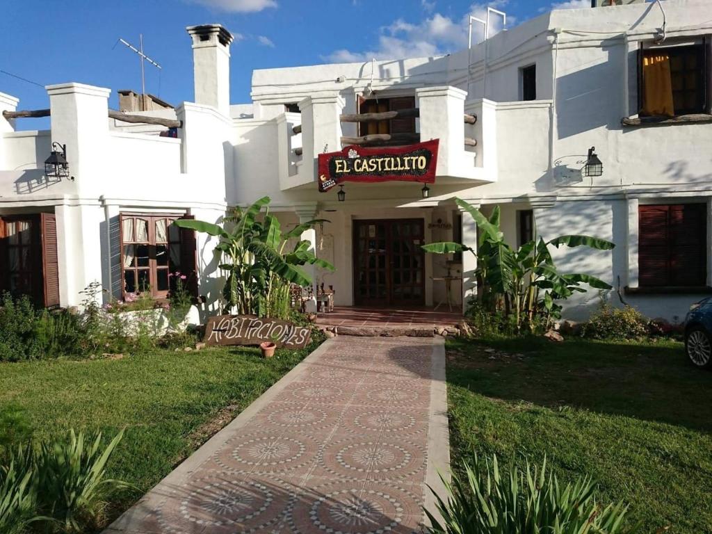 a white building with a sign on the front of it at maemm el castillto in Mina Clavero