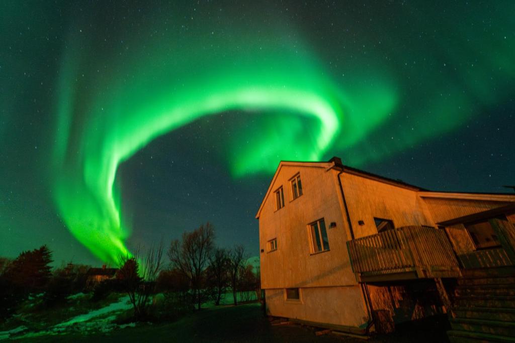 ein Bild der Aurora Borealis über einem Haus in der Unterkunft Casa Hikari - Lofoten Retreat in Vestvågøya