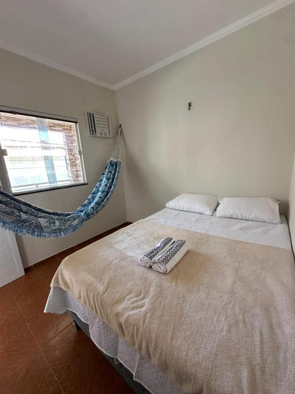 a bedroom with a bed with a remote control on it at Preá Beach Flat in Cruz