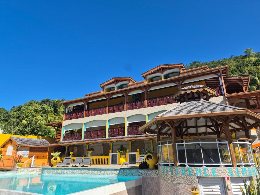 a large hotel with a pool in front of it at Résidence Simona Premium in Deshaies