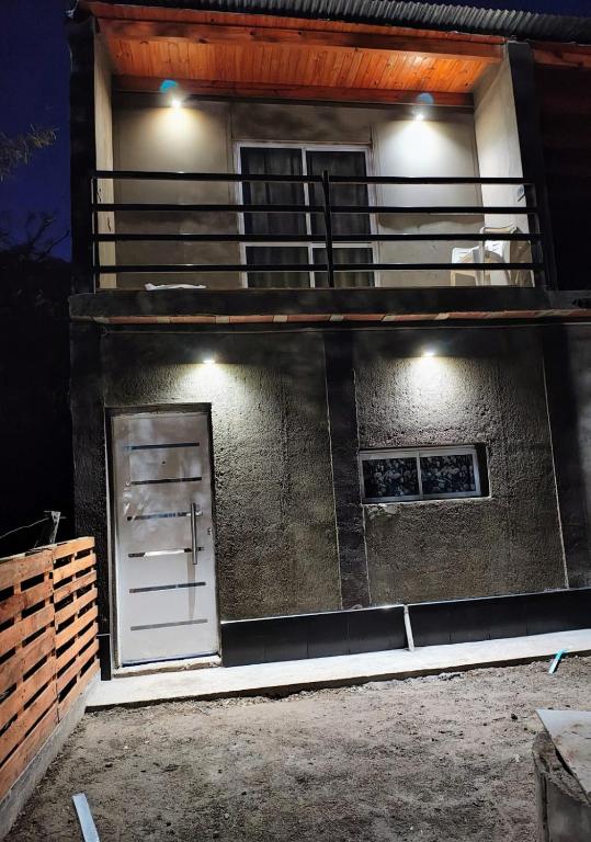 a building with a white door on the side of it at Casa de campo Pajarito in San Fernando del Valle de Catamarca