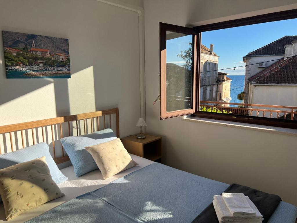 um quarto com uma cama e uma janela grande em Holiday Sun Accommodations em Orebić