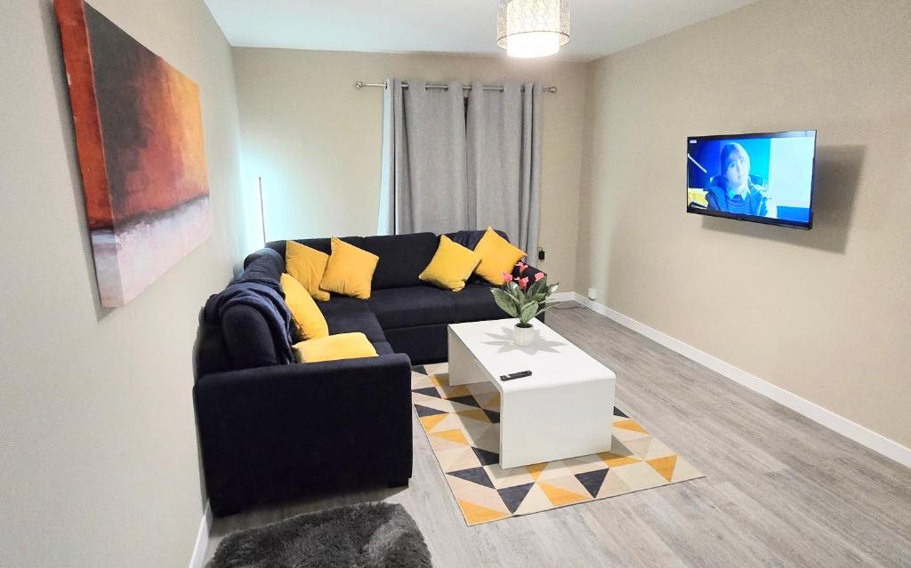 een woonkamer met een bank en een tv bij One Old Creamery in Sandhead