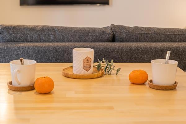 four cups on a wooden table with oranges on it at Studio Willamo in Rovaniemi