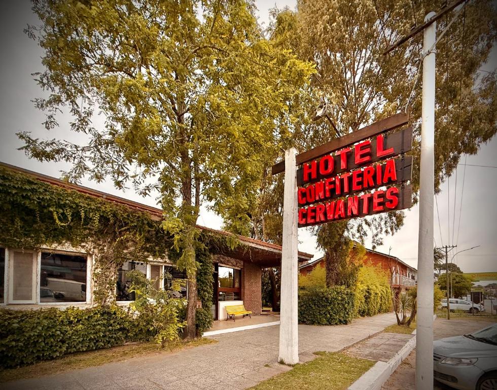 een bord voor een hotel met een gebouw bij Hotel Cervantes in Villa Gesell