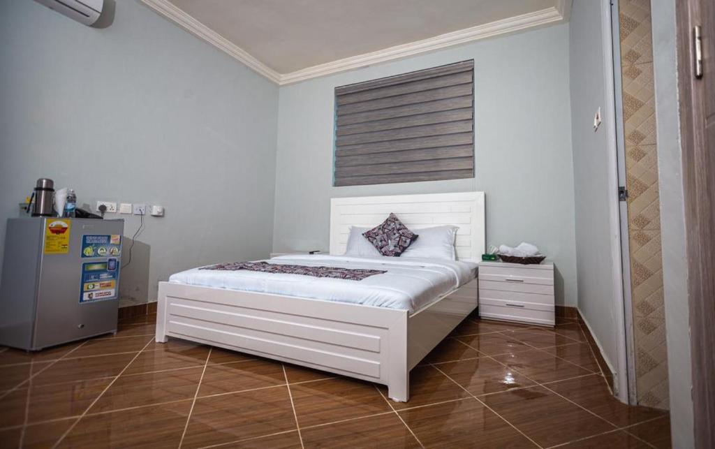 a bedroom with a white bed in a room at Gravity Hotel & lofts in Ogbojo