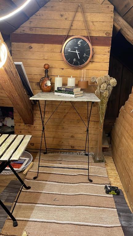 a room with a table with a clock on the wall at Solgården in Falkenberg