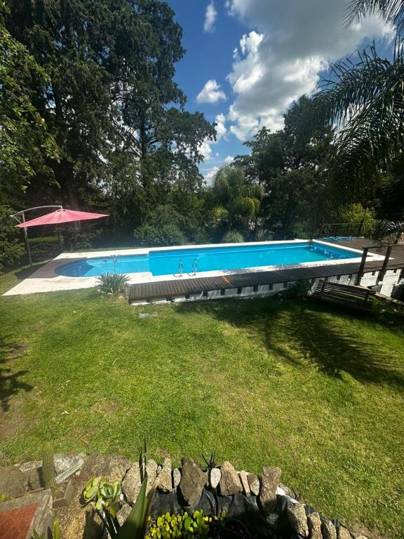 een groot zwembad in een tuin naast een veld bij Jacaranda 3 in Agua de Oro