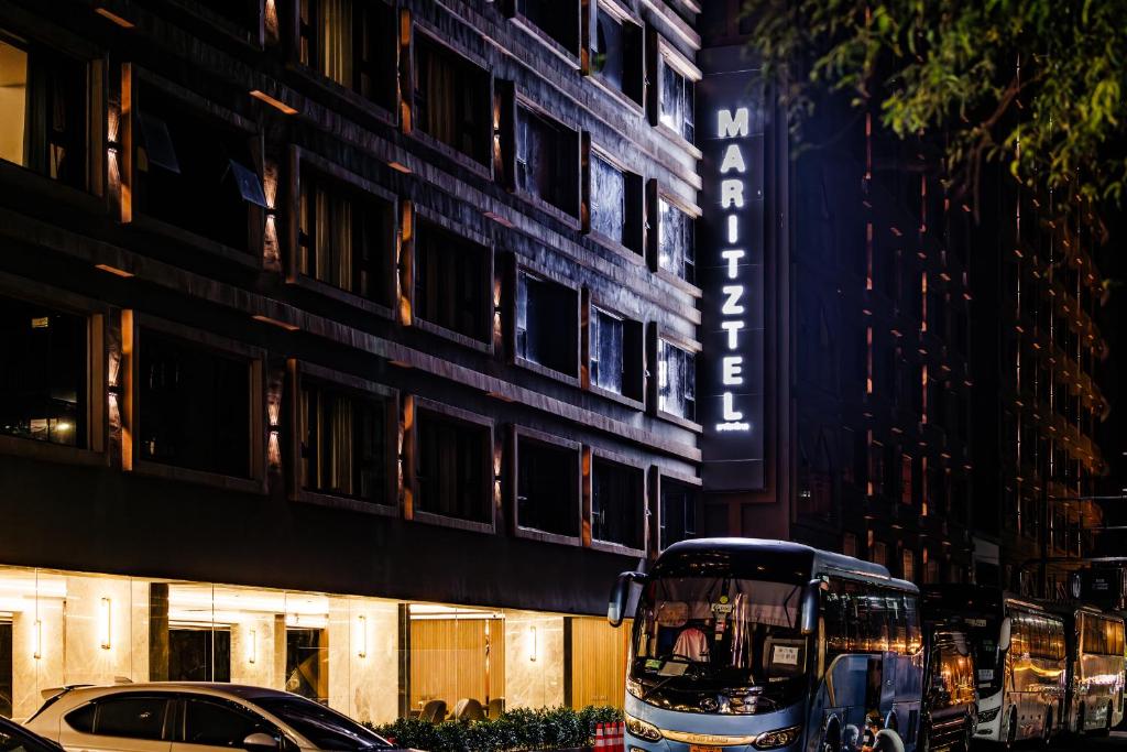 een dubbeldekkerbus geparkeerd voor een gebouw bij Maritztel Bangkok Hotel in Ban Bang Toei (1)