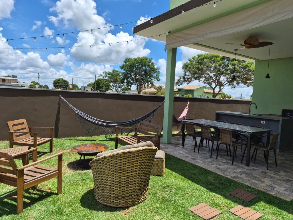 un patio con tavolo, sedie e amaca di Refugio 4 suites com ar condicionado e piscina a Águas de Santa Barbara