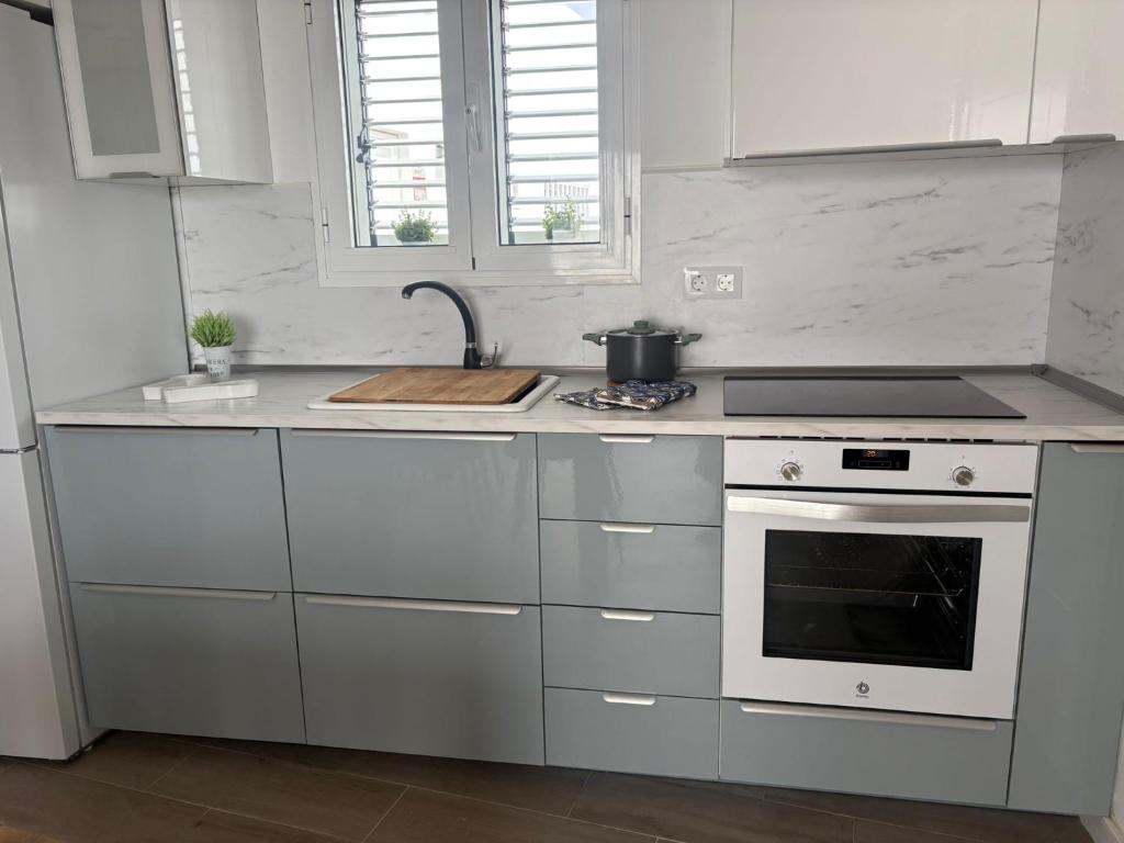 een witte keuken met een fornuis en een wastafel bij Casa Caladero in El Golfo
