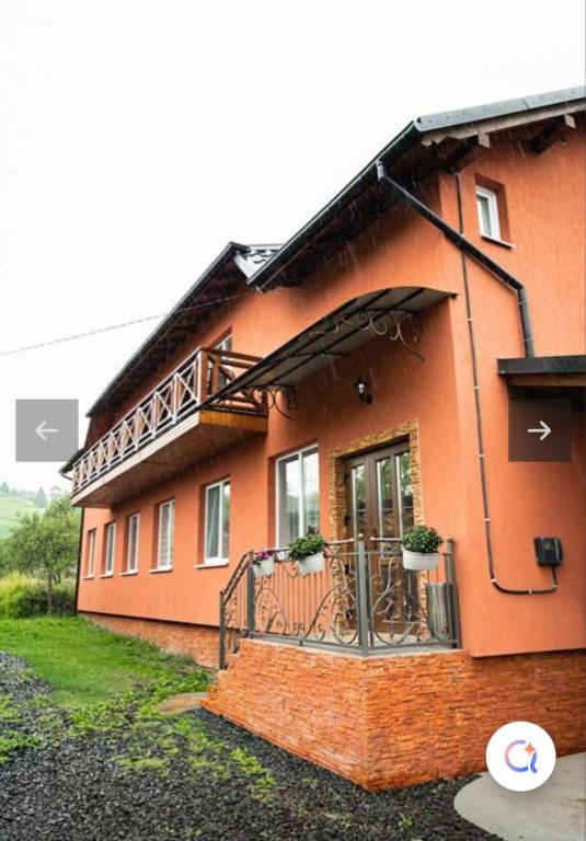 a large orange building with a balcony on it at Садиба KAMALOVA in Yasinya