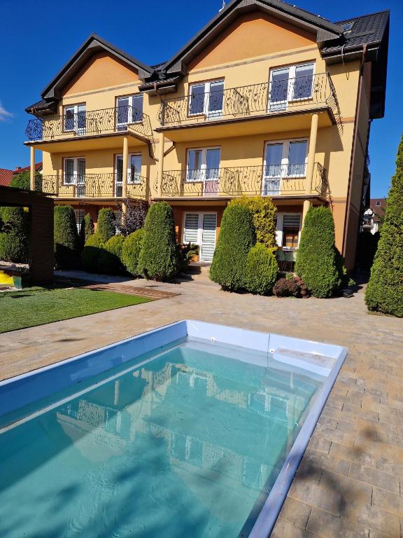 a house with a swimming pool in front of a house at Willa Nemo in Karwia