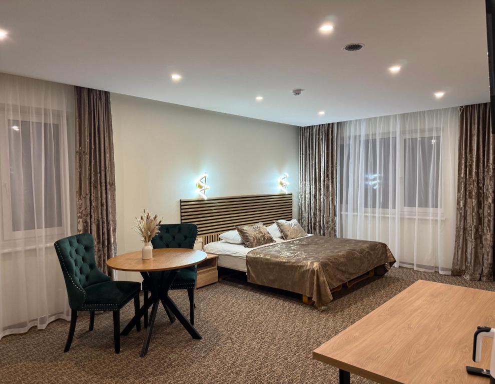 una camera da letto con un letto, un tavolo e delle sedie di Simona House a Šiauliai