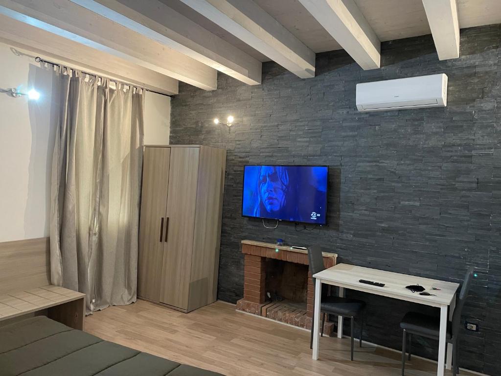 a living room with a tv on a brick wall at ROCKEFELLER SUIT Apartment in Sassari