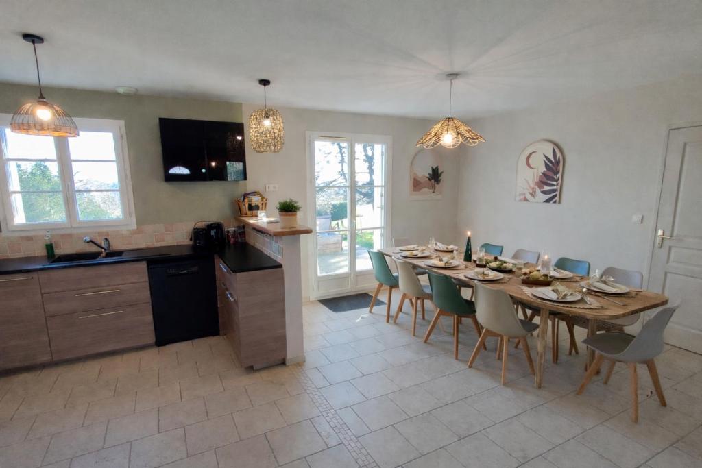 a kitchen and dining room with a table and chairs at Le Chant des étoiles in La Croix-en-Touraine