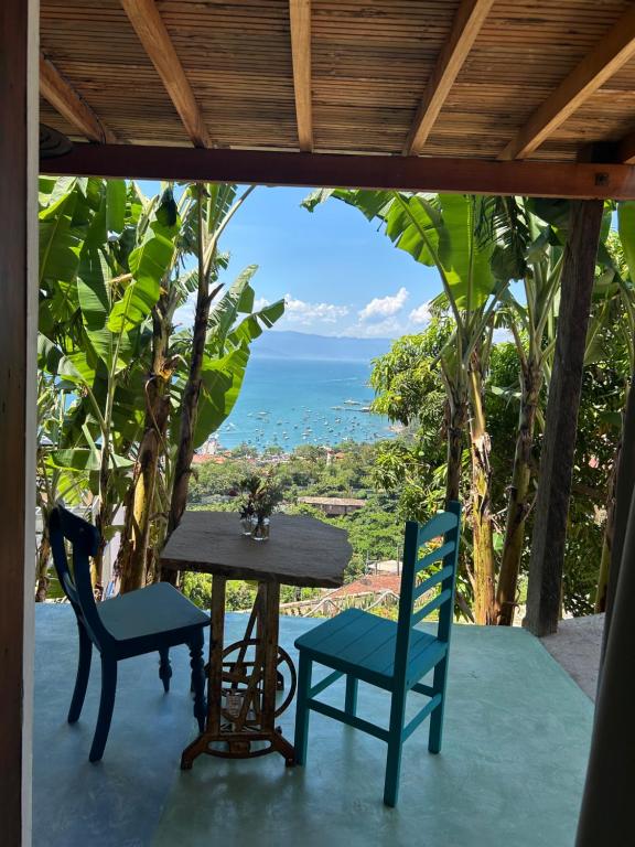 un tavolo e sedie su una veranda con vista sull'oceano di Chalé Vista Mar a Ilhabela