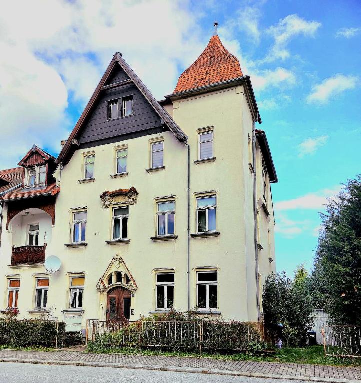 a large white building with a roof at Pension La Familia in Löbau