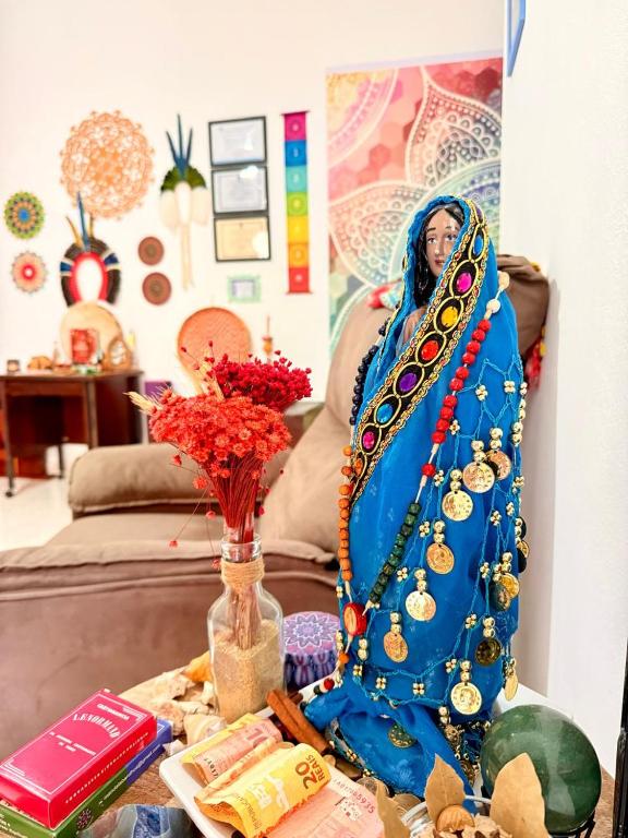 een vrouw in een blauwe jurk zittend op een tafel bij Casa Shantti in Angra dos Reis