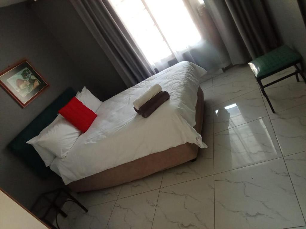 a bedroom with a bed with white pillows and a window at Unit 35 Pendleberry grove holidays in Bela-Bela