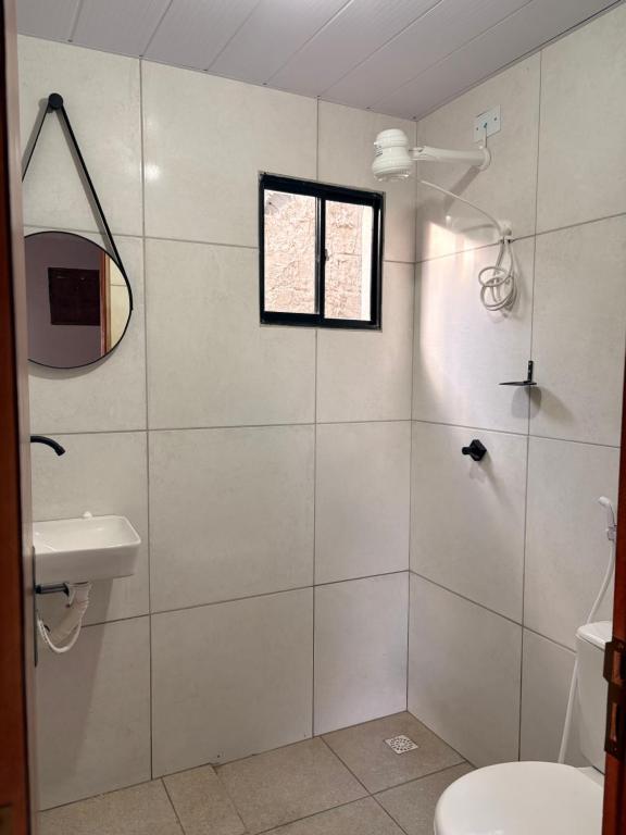 ein Badezimmer mit Dusche mit Fenster und Toilette in der Unterkunft Pousada Serena Jacumã in Conde