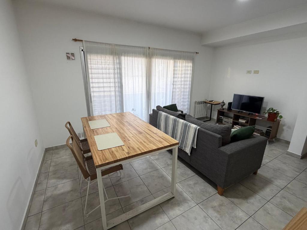 un soggiorno con un tavolo e un divano di Catedral Plaza Malvinas a La Plata