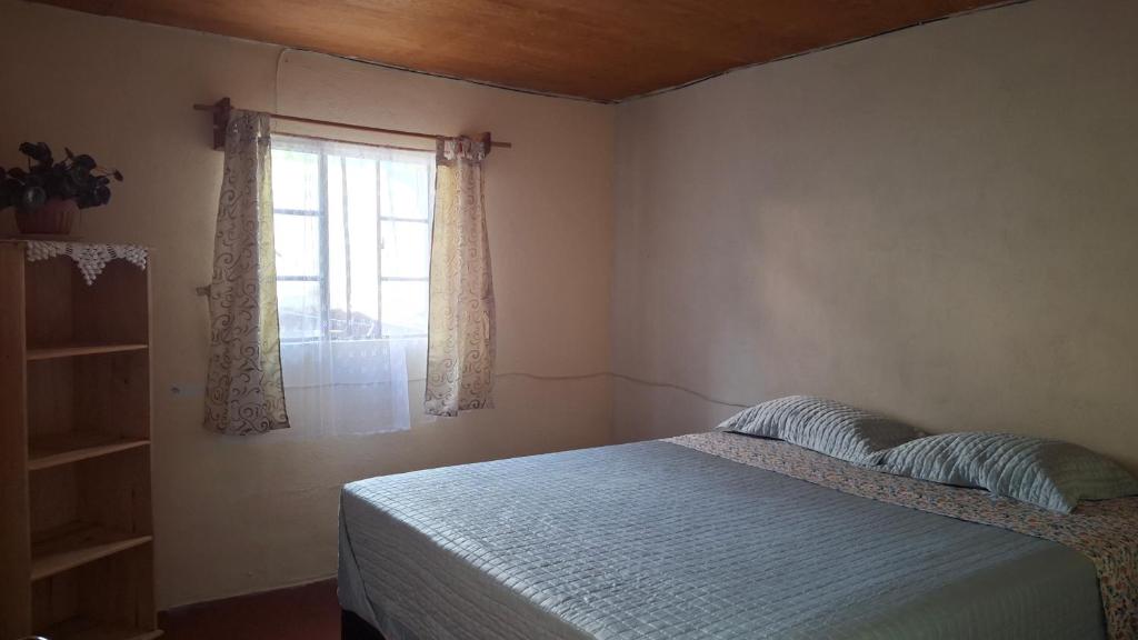 ein Schlafzimmer mit einem Bett und einem Fenster in der Unterkunft Casa Mary in Panajachel