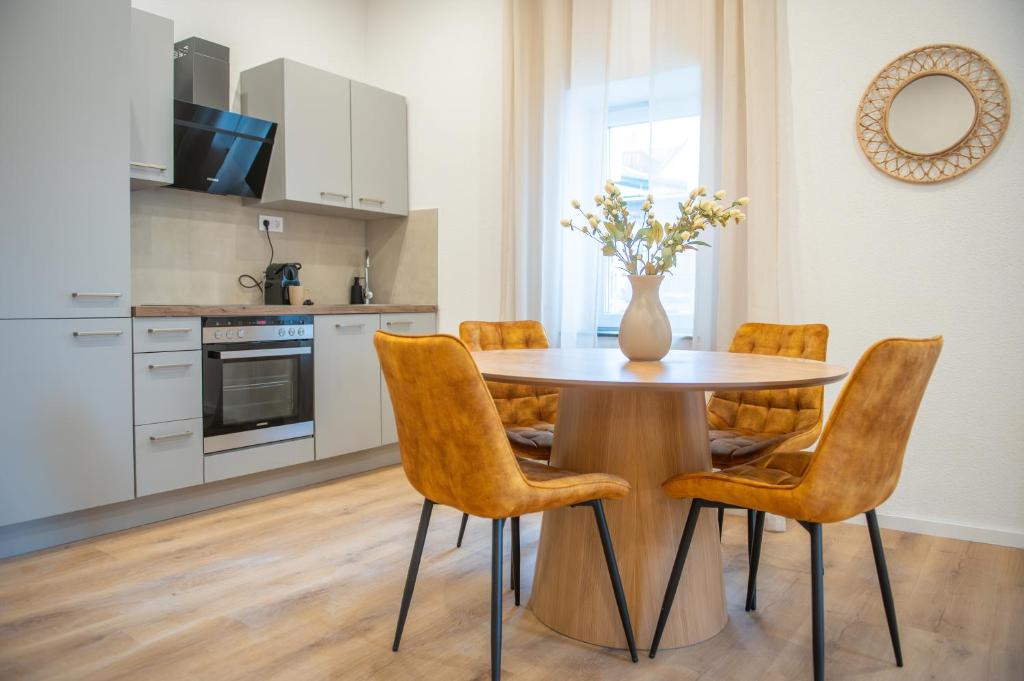 a kitchen with a table with chairs and a vase with flowers at 1 BR Bungalow - 1 Schlafzimmer - große Terrasse - Café - Sekt - an den Weinbergen in Rüdesheim am Rhein