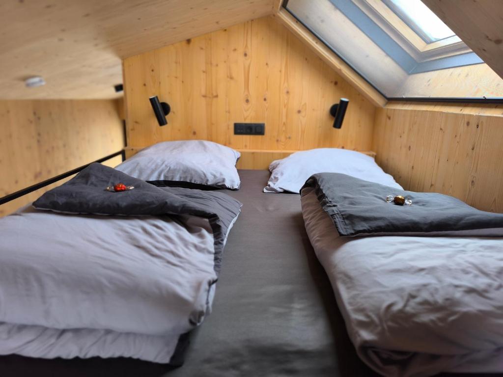 twee bedden in een kamer met houten wanden bij Tiny House 1 im schönen Allgäu mit großem Garten, Naturnah in Bad Wurzach