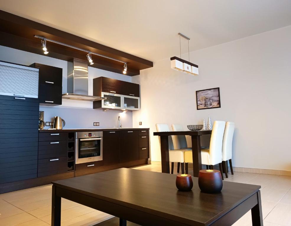 a kitchen with a table and a dining room at Apartament WENGE w centrum Ustronia in Ustroń