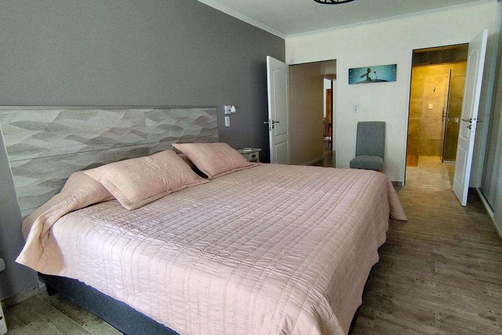 een slaapkamer met een groot bed en een roze dekbed bij Arrabal.Tupungato in Tupungato