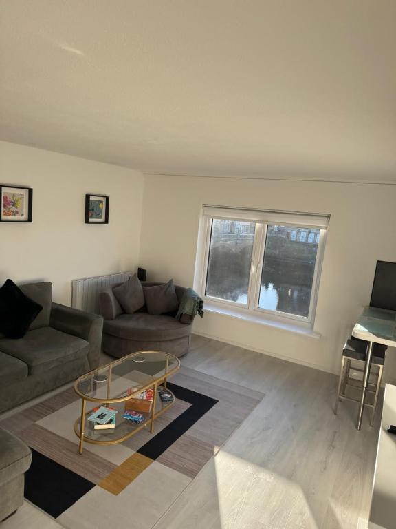 a living room with a couch and a glass table at Exceptional 1 bedroom riverside 2E apartment in Ayr