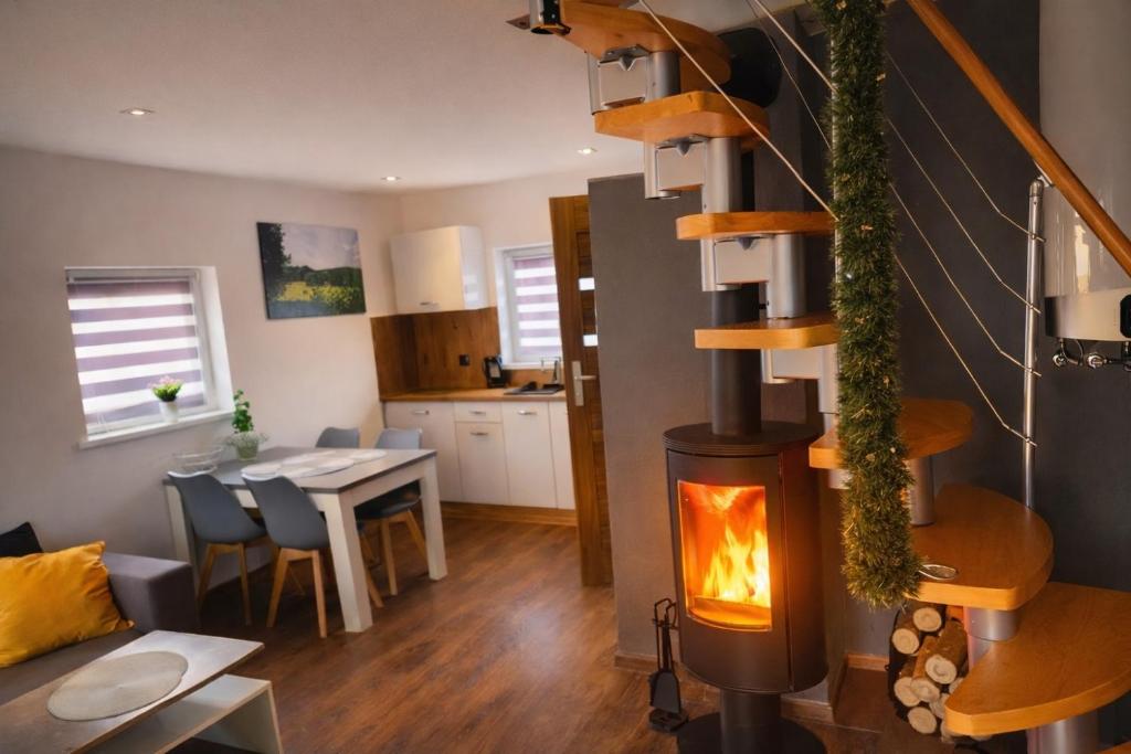 een woonkamer en keuken met een houtkachel bij SunSet Radków in Radków