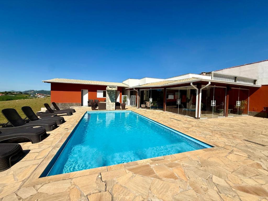a swimming pool with lounge chairs next to a house at A Casinha in Socorro
